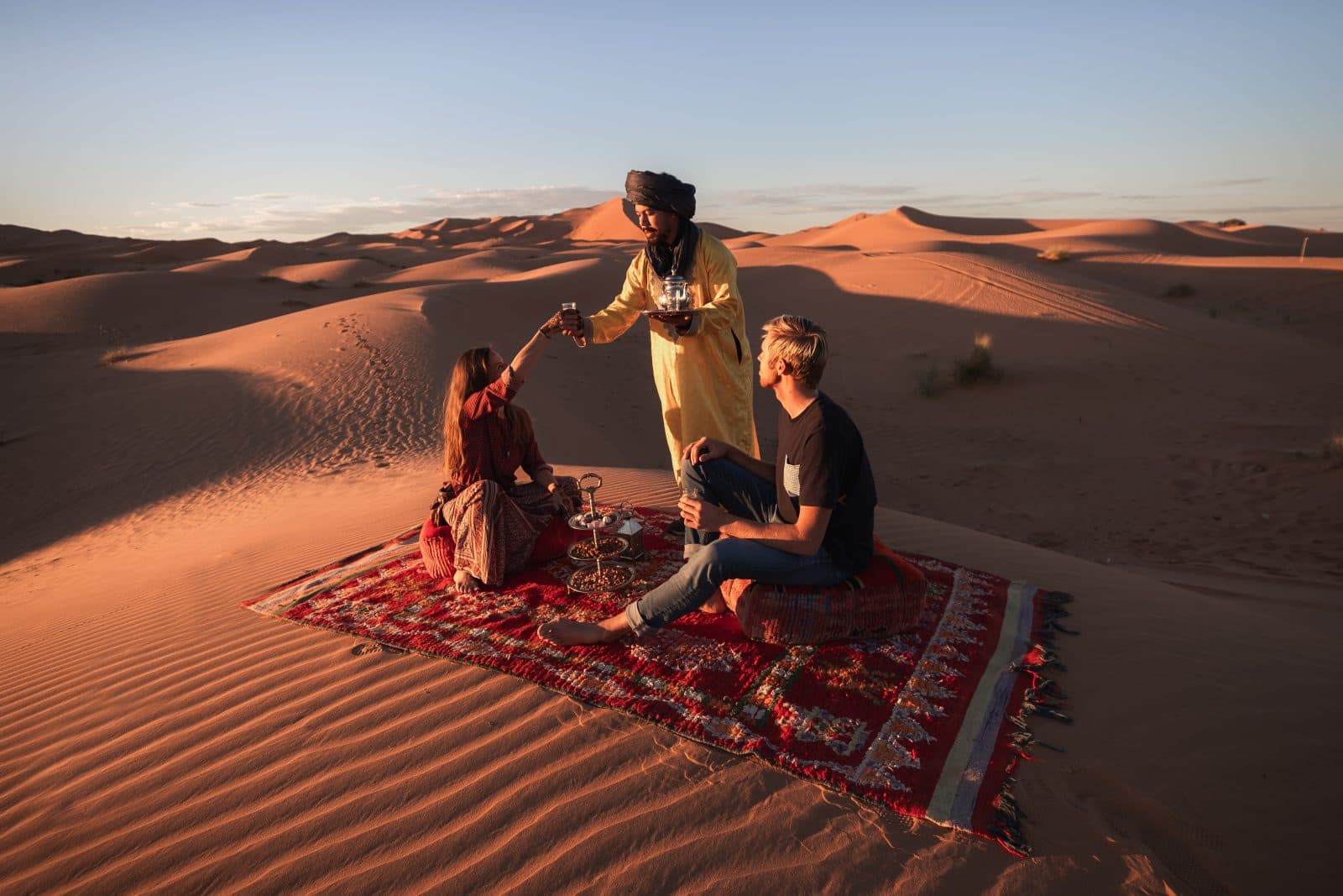 Traditional tea service on a Berber rug atop a dune near Tiziri Camp